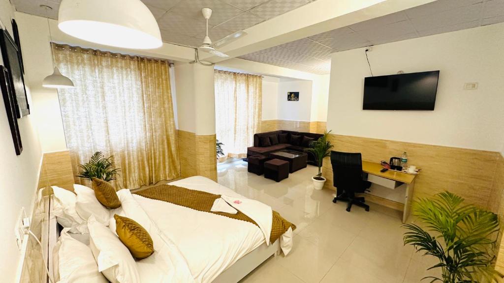 诺伊达Hotel Relax In - Noida Sector 18的一间卧室配有一张床、一张桌子和一张沙发