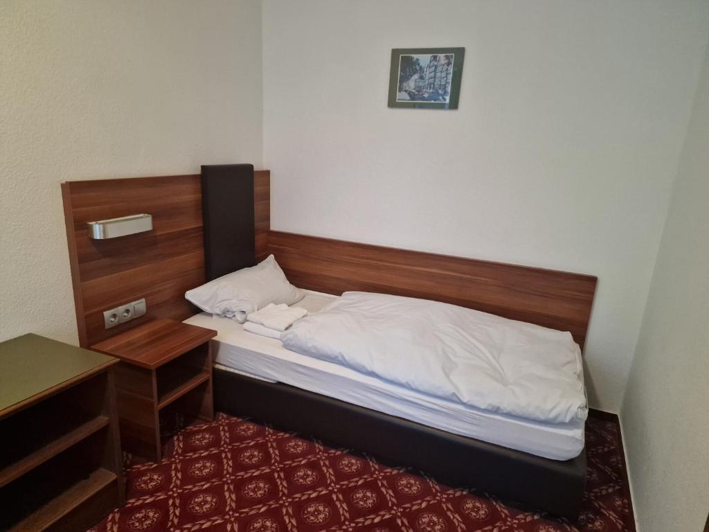 豪恩斯泰因Landhotel Neding的一间卧室配有一张带木制床头板的床和一张书桌