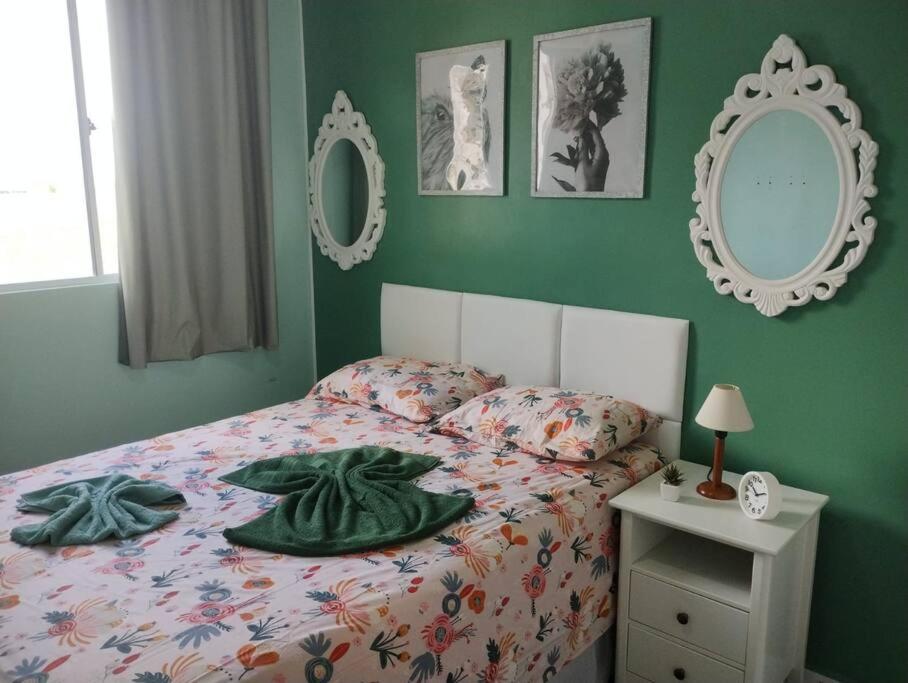伊波茹卡Cantinho da Ju的卧室内的一张床位,卧室内拥有绿色的墙壁和镜子
