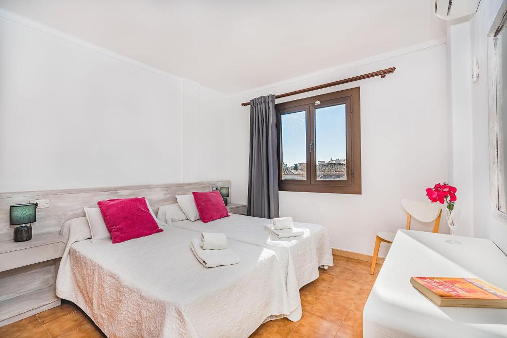 波连萨港布里索尔公寓的白色客房内的两张床和粉红色枕头