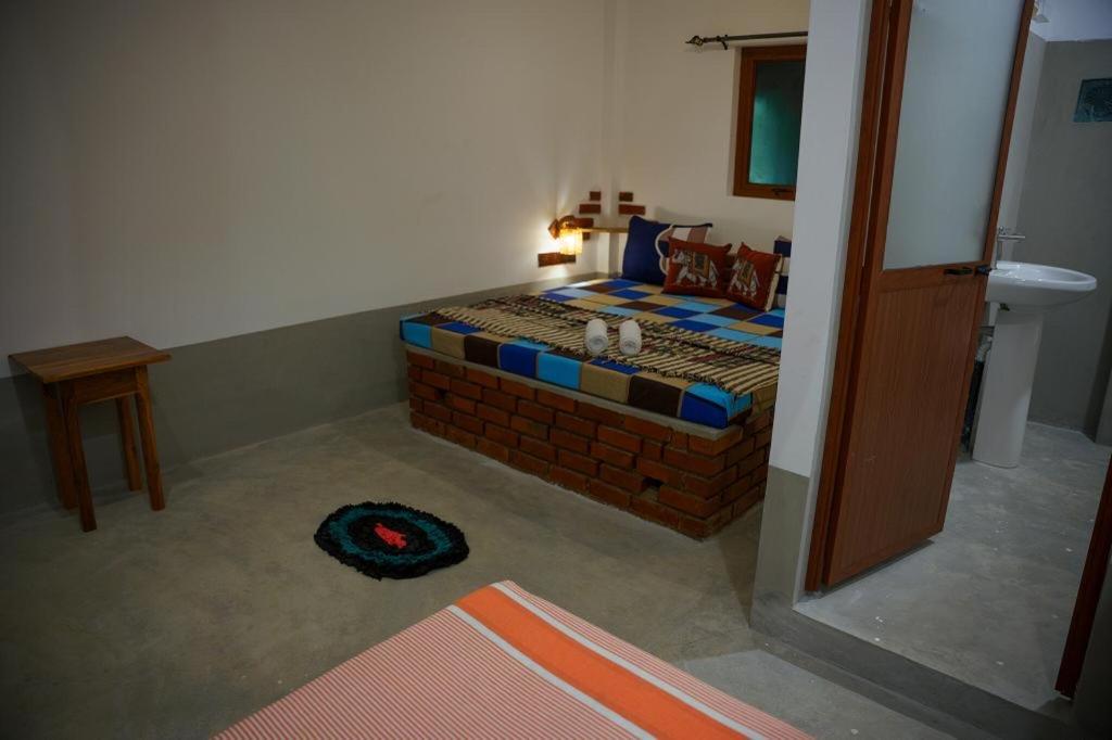 AchchamulaiWilpattu Green Cabin的卧室配有一张砖墙铺床