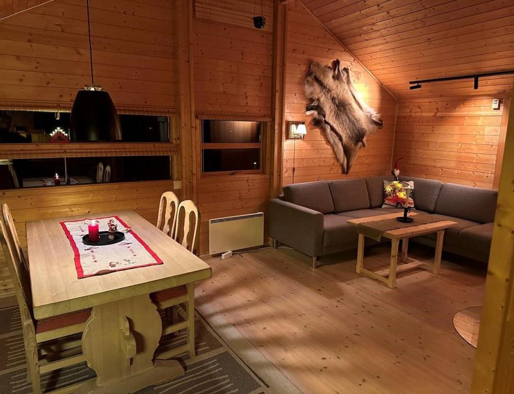 HoloKinnkosen - cabin with panoramic view for 6 persons的客厅配有沙发和桌子