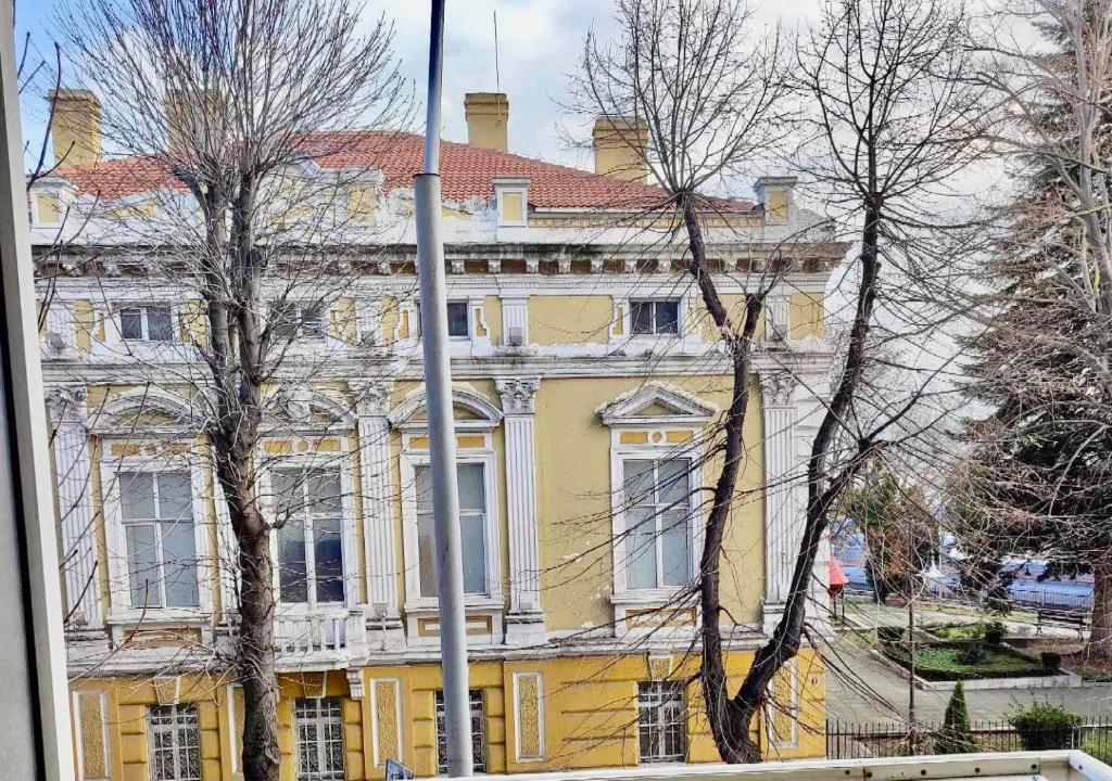 瓦尔纳Primorski Apartment的红色屋顶的大型黄色建筑