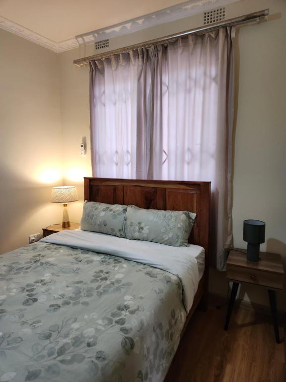 卢萨卡Emerald Hill 145 Kunda的一间卧室设有一张大床和窗户