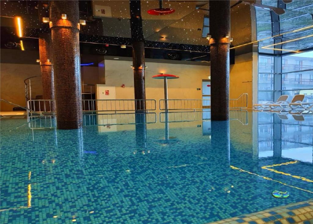 尤斯托尼莫斯基Hotel SKAL Medi SPA & Resort的一座带椅子的建筑里的一个水池