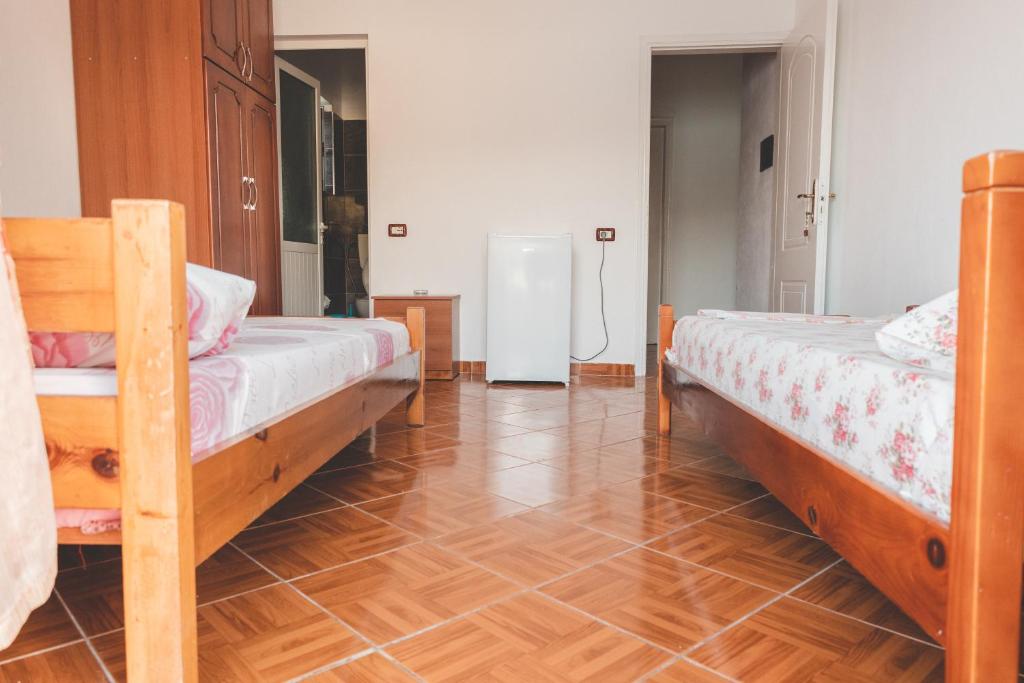 希马拉Room with amazing sea view的一间卧室设有两张床,铺有木地板