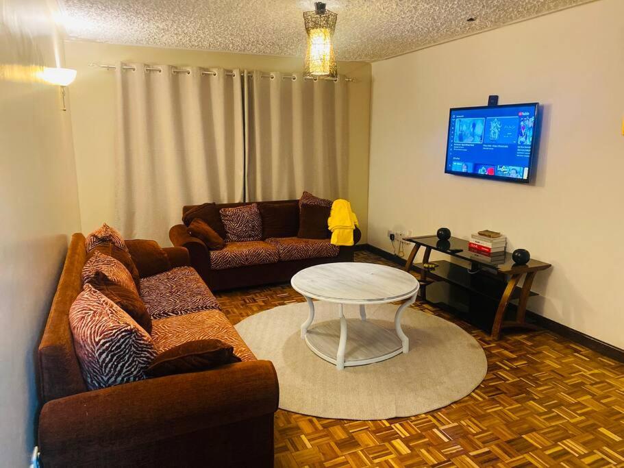 内罗毕Pristine Luxury 2 bedroom Apartment-South C的客厅配有沙发和桌子