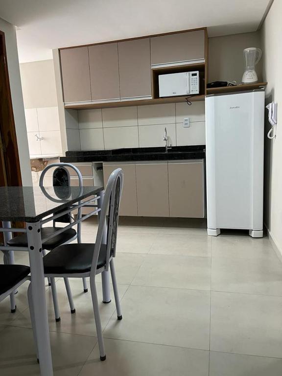 北茹阿泽鲁Flats Prime的厨房配有桌椅和冰箱。