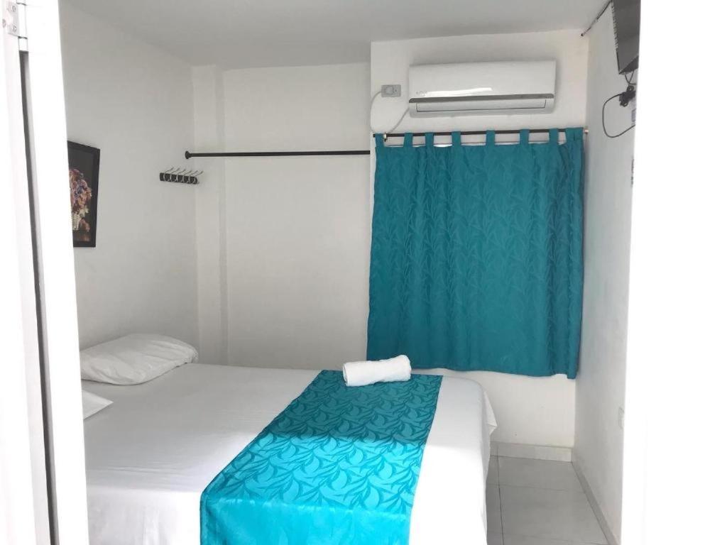 巴耶杜帕尔Hotel URUMITA MAGICA的小房间,配有床和蓝色窗帘