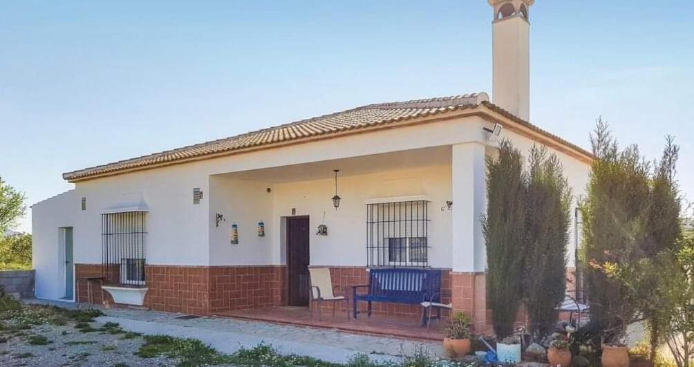 奥尔维拉Las Cormenillas的前面有蓝色长椅的小白色房子