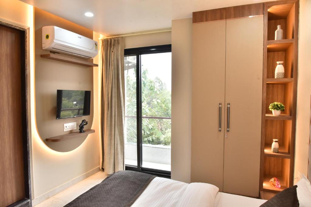 斋浦尔Hotel Shree Krishna的一间卧室设有一张床、一台电视和一个窗口。