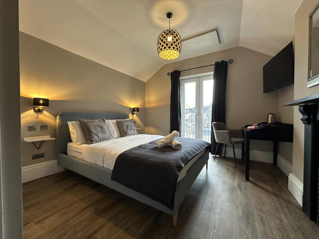 卡迪夫第一百住宿加早餐酒店的一间卧室配有一张床、一张桌子和一个窗户。