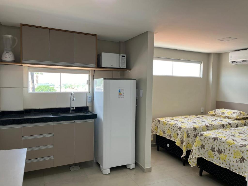 北茹阿泽鲁Pousada Prime的一间带冰箱的厨房,床边设有冰箱