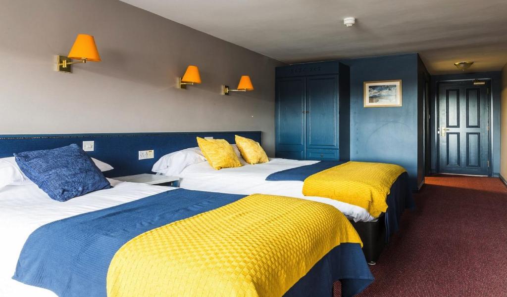 纽卡斯尔The Donard Hotel的酒店客房带两张黄色和蓝色的床