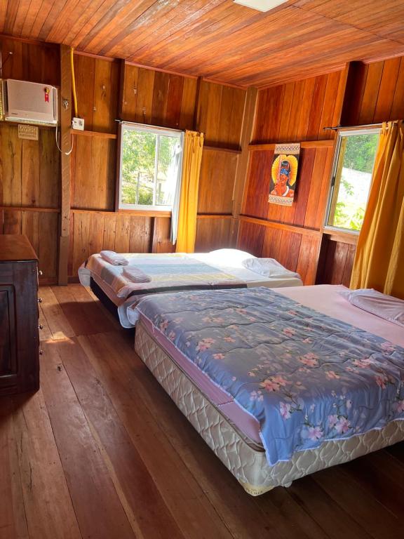 ManacapuruCasa Encanto的木制客房内的一间卧室配有两张床
