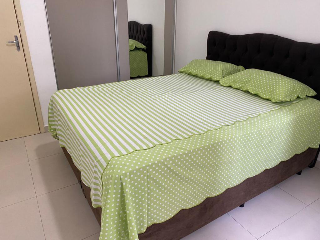 圣维森特岛Apartamento na praia的一张带绿色和白色床单及枕头的床