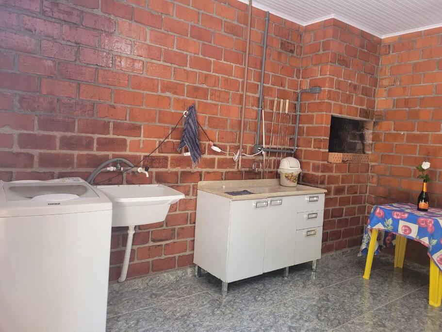 卡洛斯-巴尔博萨Casa de campo em Carlos Barbosa - Serra Gaúcha的厨房设有水槽和砖墙