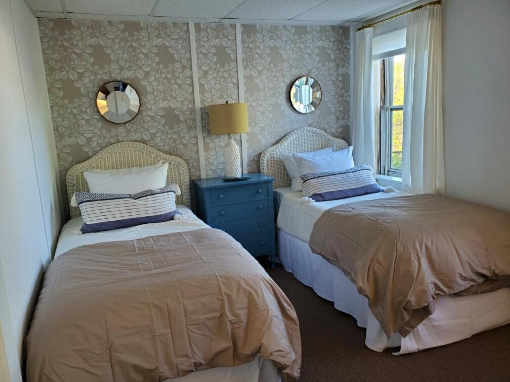 新肖雷汉姆Barrington Inn Barn的一间卧室设有两张床和窗户。