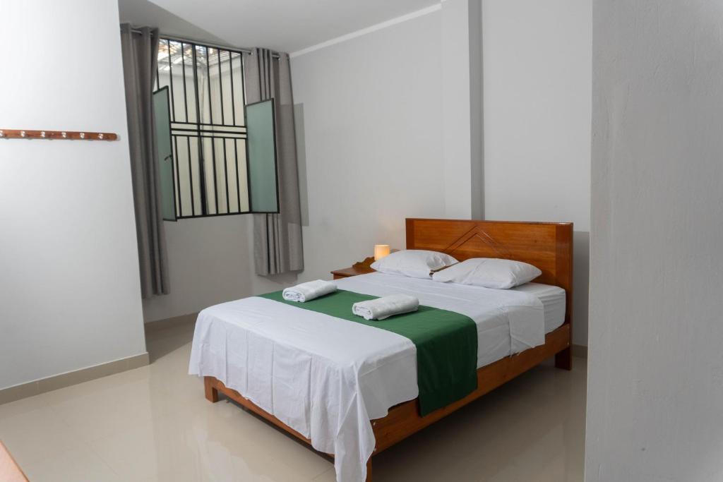 塔拉波托Humazapa的一间卧室配有一张带白色床单的床和一扇窗户。