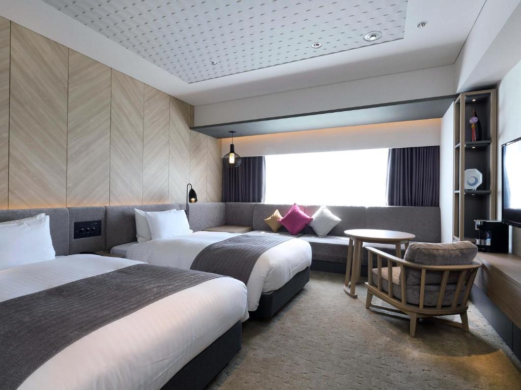 福冈福冈日光西铁酒店的酒店客房,设有两张床和一张沙发