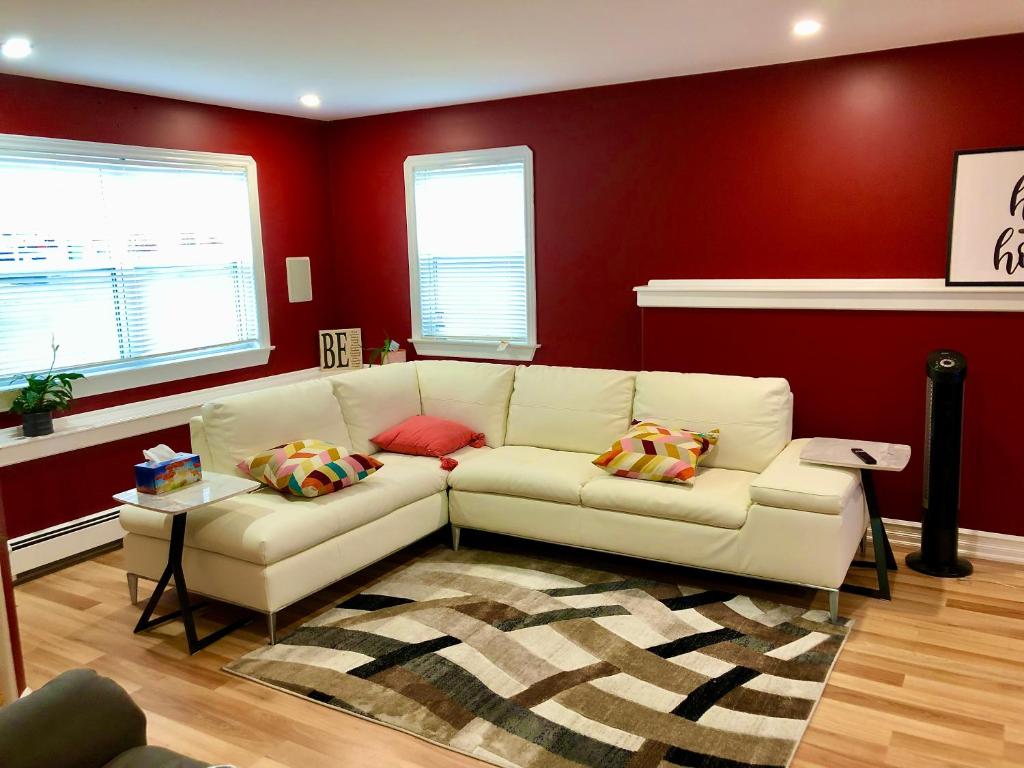 哈利法克斯Vito Place的客厅设有白色沙发和红色墙壁。