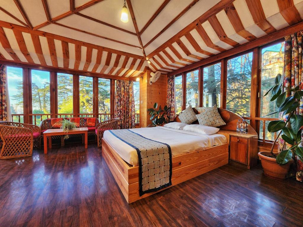 西姆拉Hotel Pineview Shimla的一间设有床铺的卧室,位于带窗户的房间内