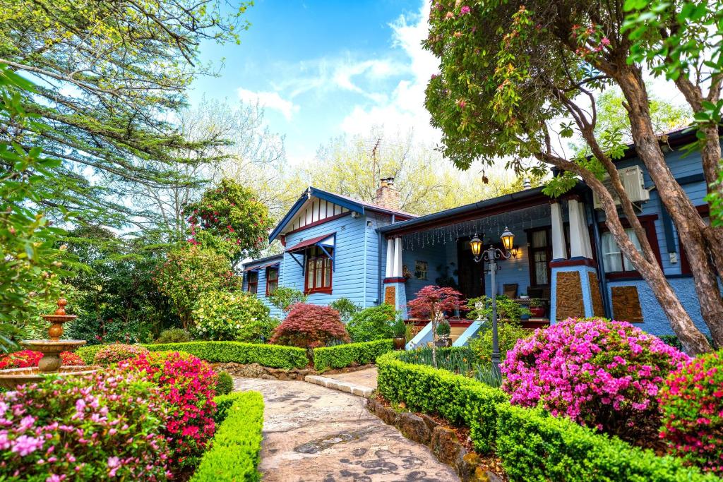 黑荒地KUBBA ROONGA GUESTHOUSE - Boutique Luxury Peaceful Stay & Gardens - showcasing Heritage features & Spa's - Devonshire Tea's n Scones - Breakfast included的前面有鲜花的蓝色房子