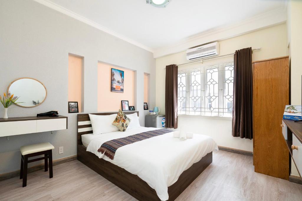 胡志明市Planet Homestay的一间卧室设有一张大床和一个窗户。