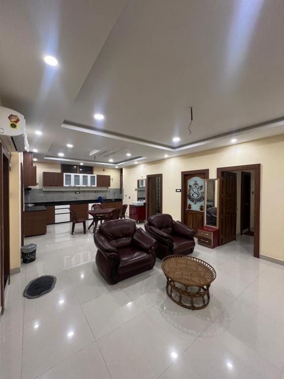 德奥加尔Shrinath Palace的客厅配有皮革家具和钢琴