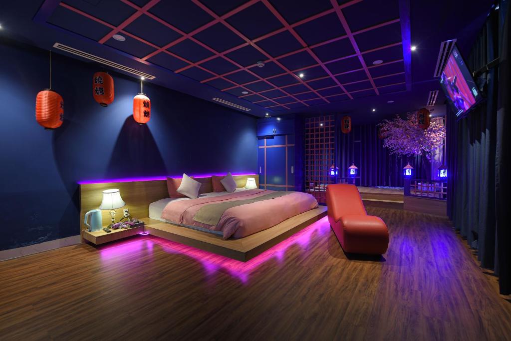 岘港Chiic House 1 - Khách sạn tình yêu的卧室配有床、椅子和灯