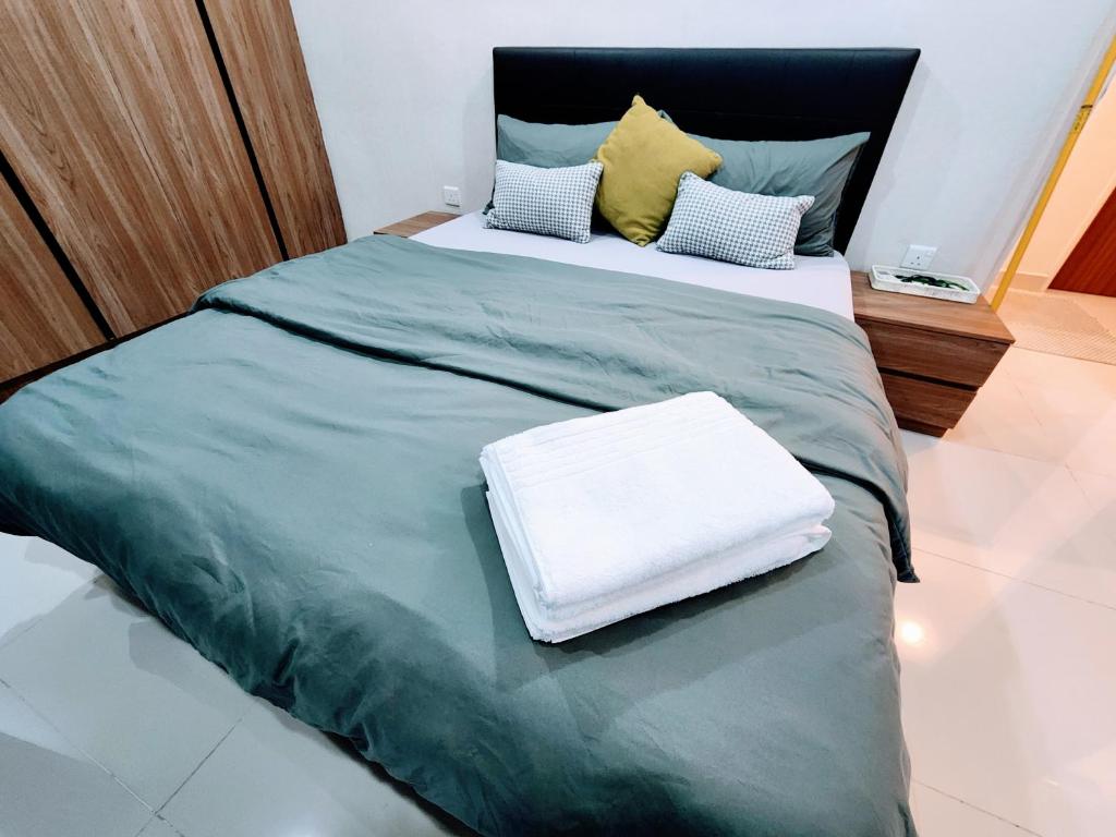 古晋Kozi Square Twin Room with free Wi-fi & Carpark的一张带绿毯和枕头的大床