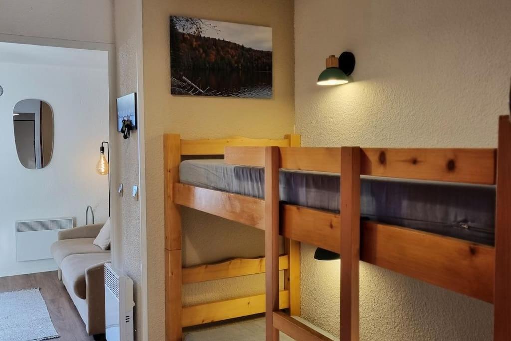 米茹Le Montagnard的一间带两张双层床和一张沙发的卧室