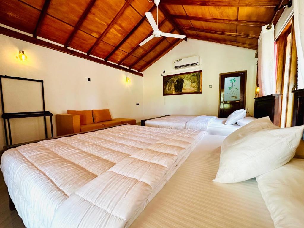 维勒珀图Green Sapphire Holiday Resort Wilpaththu的一间带两张床和一张沙发的大卧室