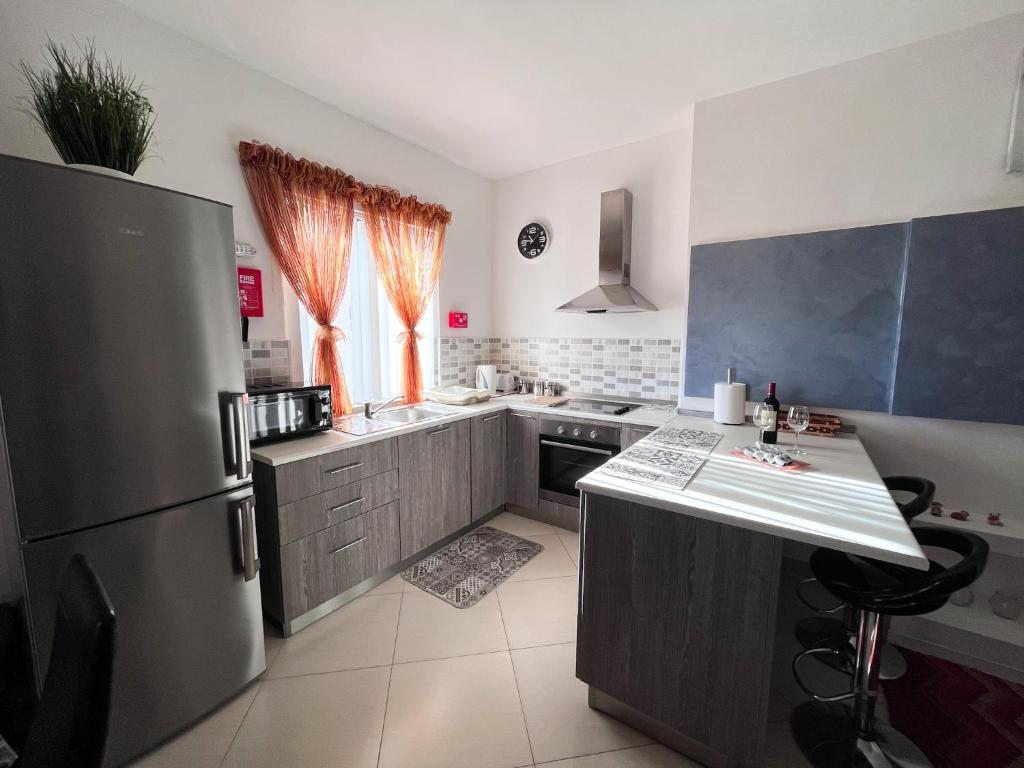 卢加Modern Spacious 2BD Penthouse with 2 Terraces - Close to Luqa Airport的厨房配有不锈钢冰箱和台面