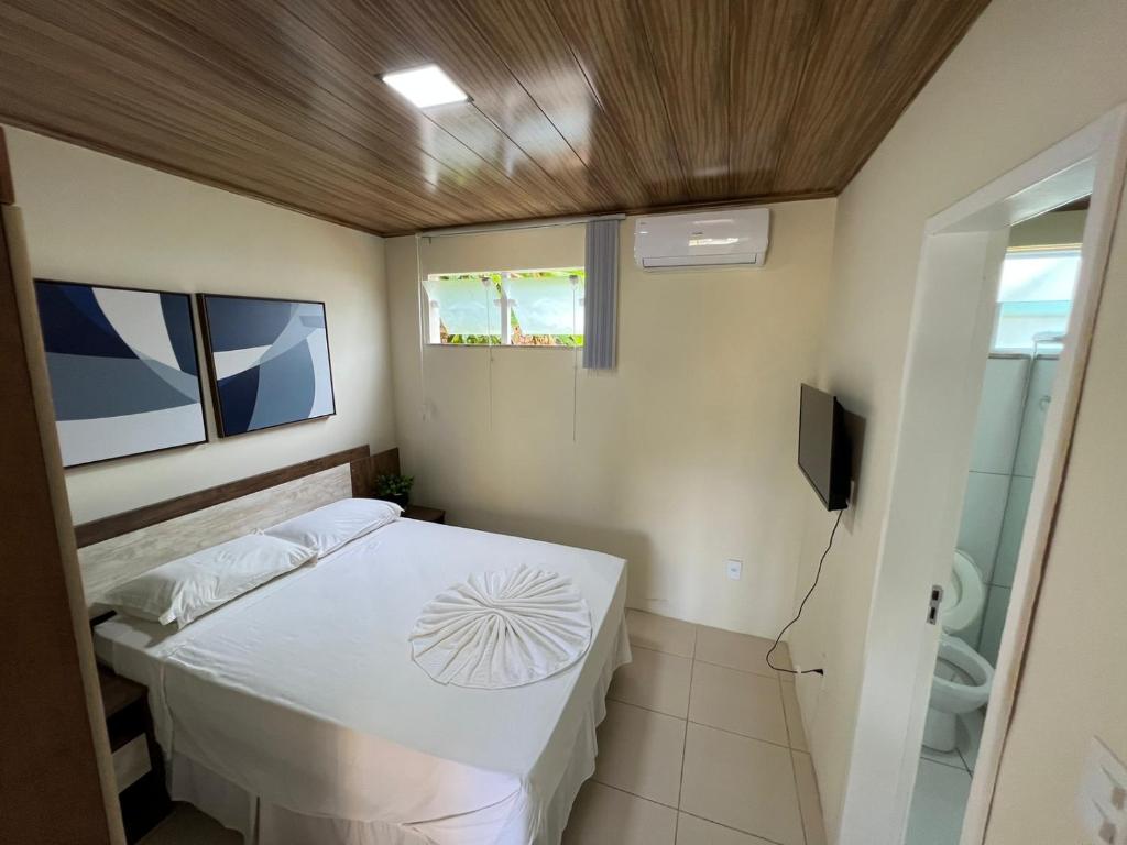 Bôca do RioApartamento em Itaparica的一间小卧室,配有一张床和电视