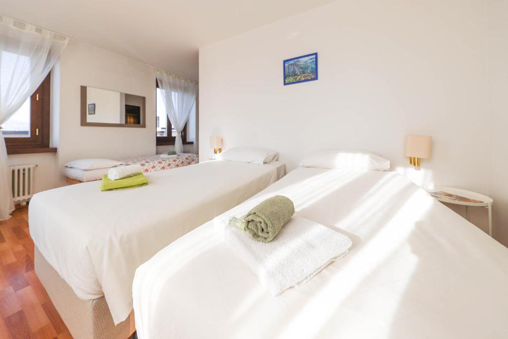 BalernaCasa Zen的白色客房内的两张床和毛巾