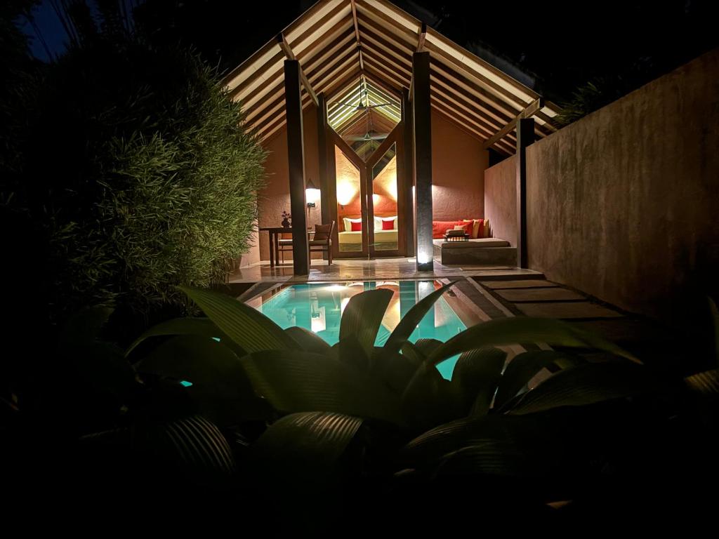 希克杜沃Nisala Villas的一座晚上设有游泳池的房子
