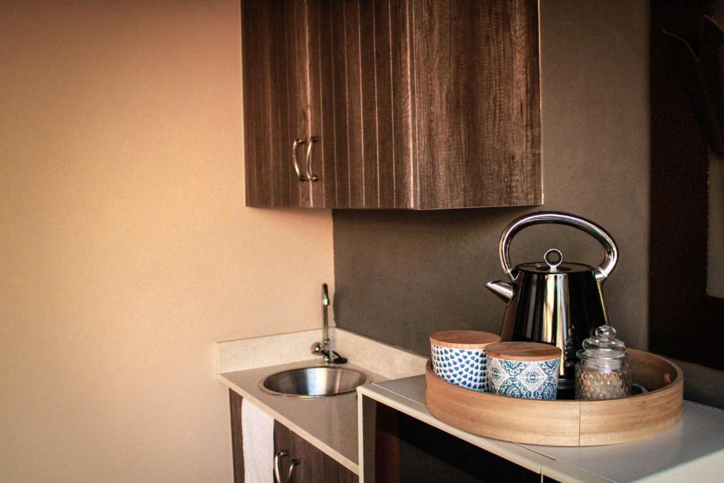 莫塞尔湾C-Vu-Cottage cosy and warm private apartment的厨房柜台配有茶壶和餐具。