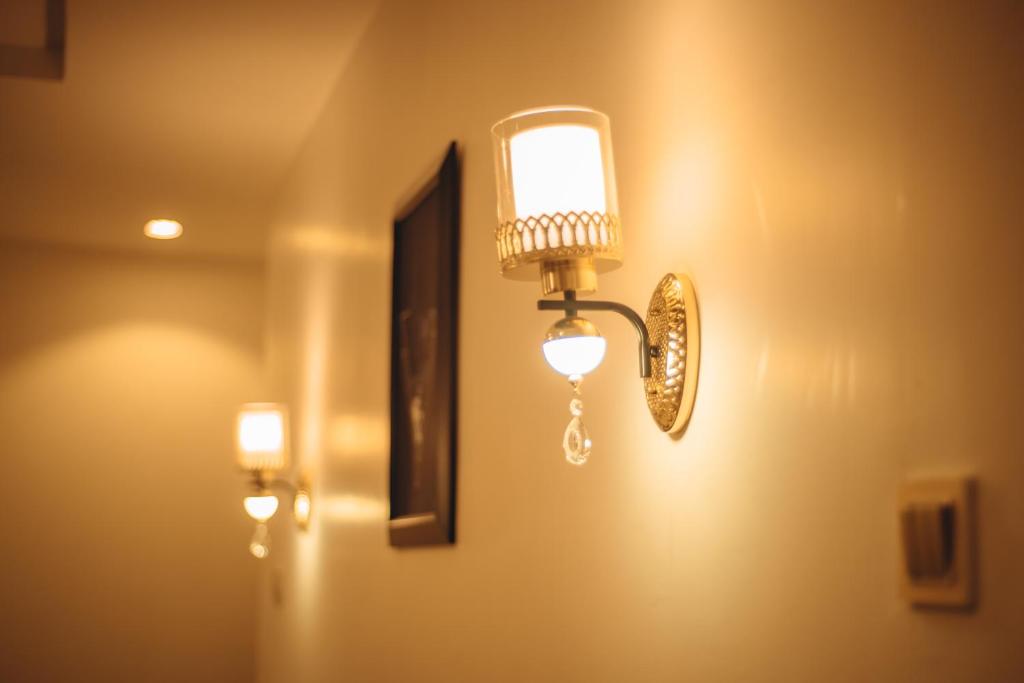 卡杜纳Hols Apartments的墙上的灯,上面有镜子