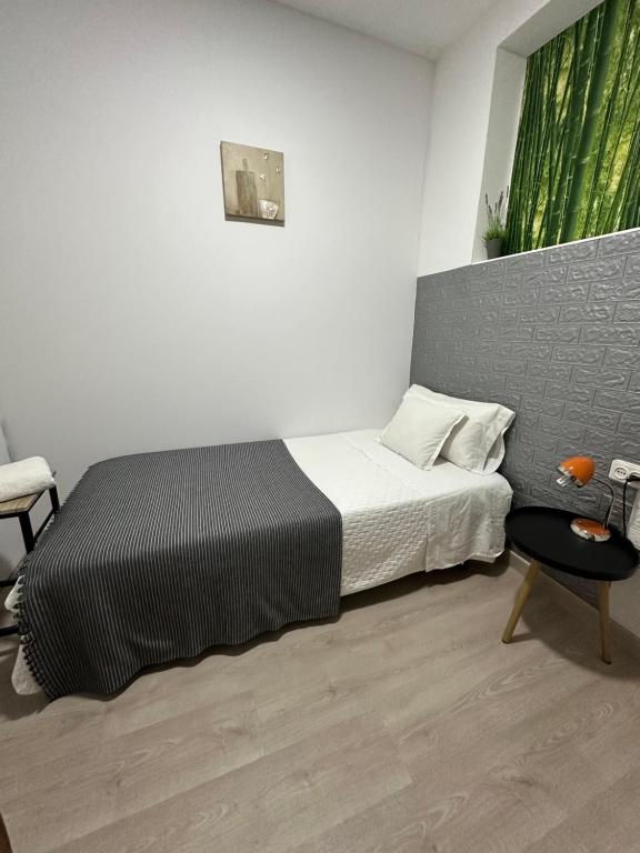 维多利亚-加斯特伊兹Apartamento Kalea corazón urbano的一间小卧室,配有一张床和一把椅子