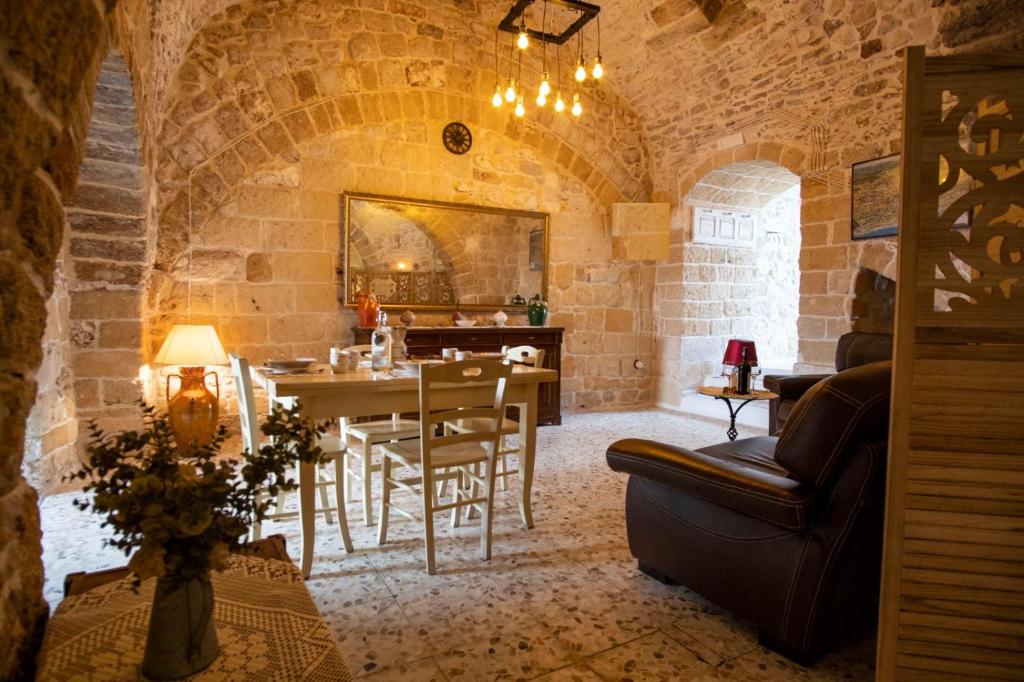 卡洛维诺DOMUS CESARE-dimora storica totalmente in pietra nel cuore del centro storico con cabina doccia pietra in camera e zona relax esterna-historic residence entirely made of stone in the heart of the historic center with stone shower cabin in the room的一间带桌子的客厅和一间餐厅