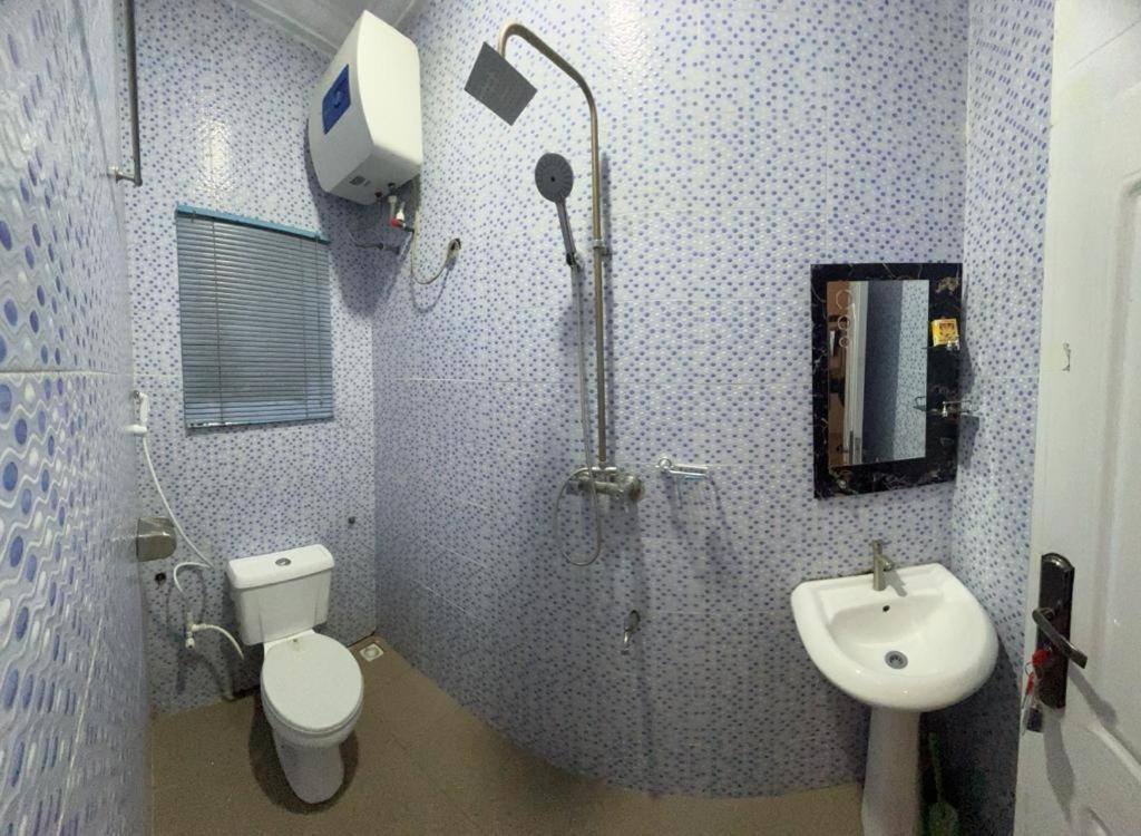 哈科特港Owtee’s Apartments的带淋浴、卫生间和盥洗盆的浴室