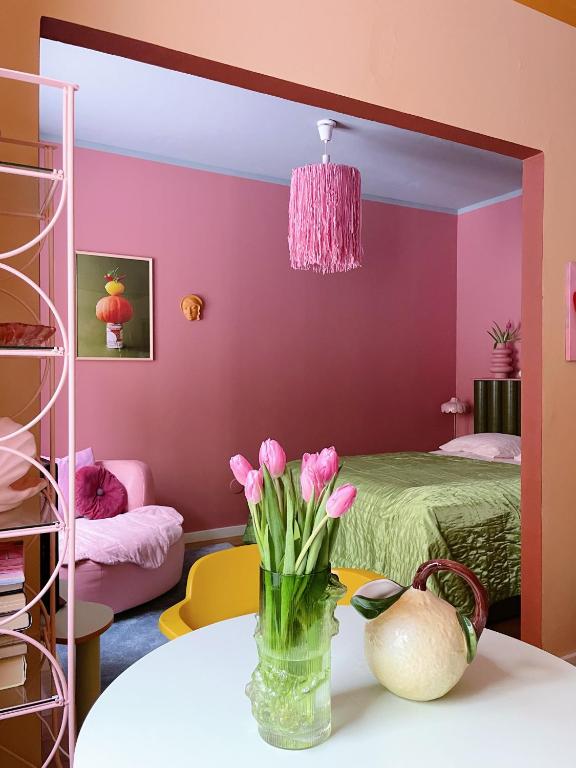 赫尔辛基Värikäs koti lähellä keskustaa的一张桌子上放着一团粉红色花的房间里