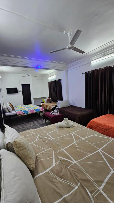 达曼Hotel Sagar Darbar的一间带一张床的客厅和一间带沙发的客厅