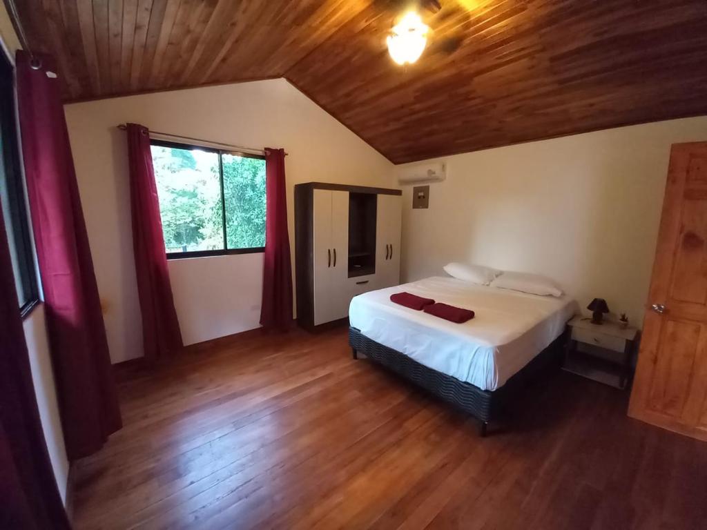 塔马林多Aura Bungalow的一间卧室配有一张床,铺有木地板