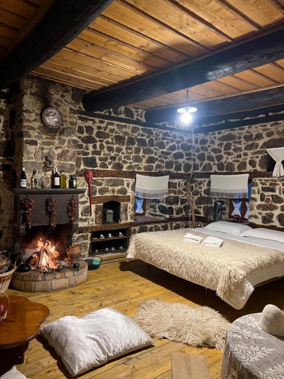BulqizëKulla Hupi Agriturism的一间卧室设有一张床和一个壁炉