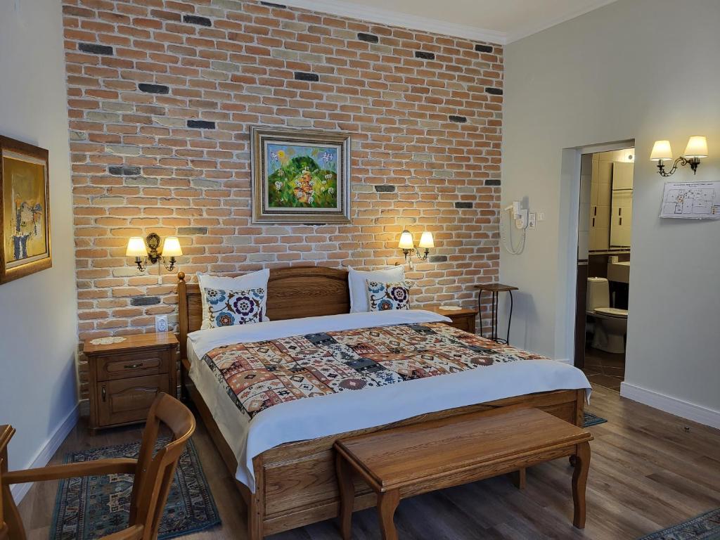 普罗夫迪夫Hotel Odeon的一间卧室设有一张带砖墙的大床