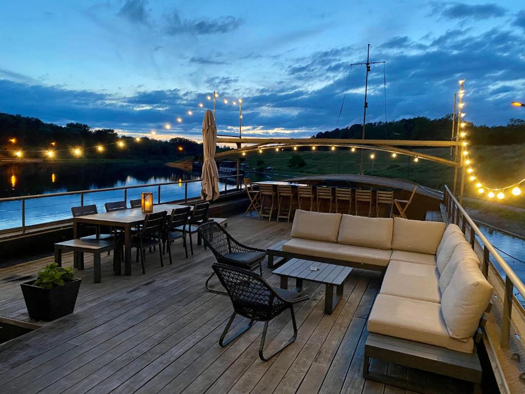 伊特尔Tabor 67 Luxury Houseboat的木制甲板配有沙发和桌椅