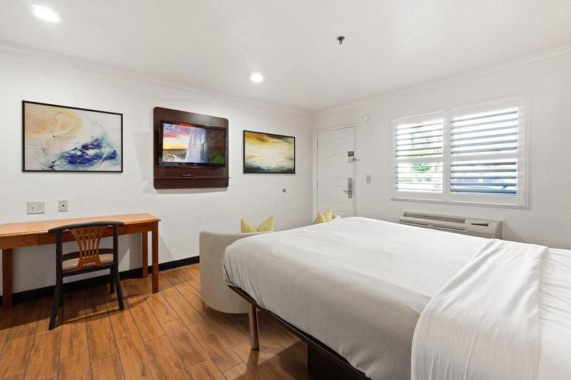 安大略Motel 6的白色卧室配有床和书桌
