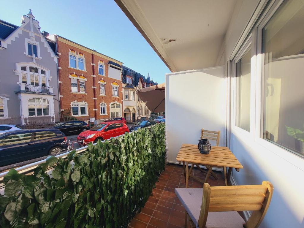 特里尔Zentrales Apartment mit Balkon und Parkplatz的阳台配有木桌和长凳